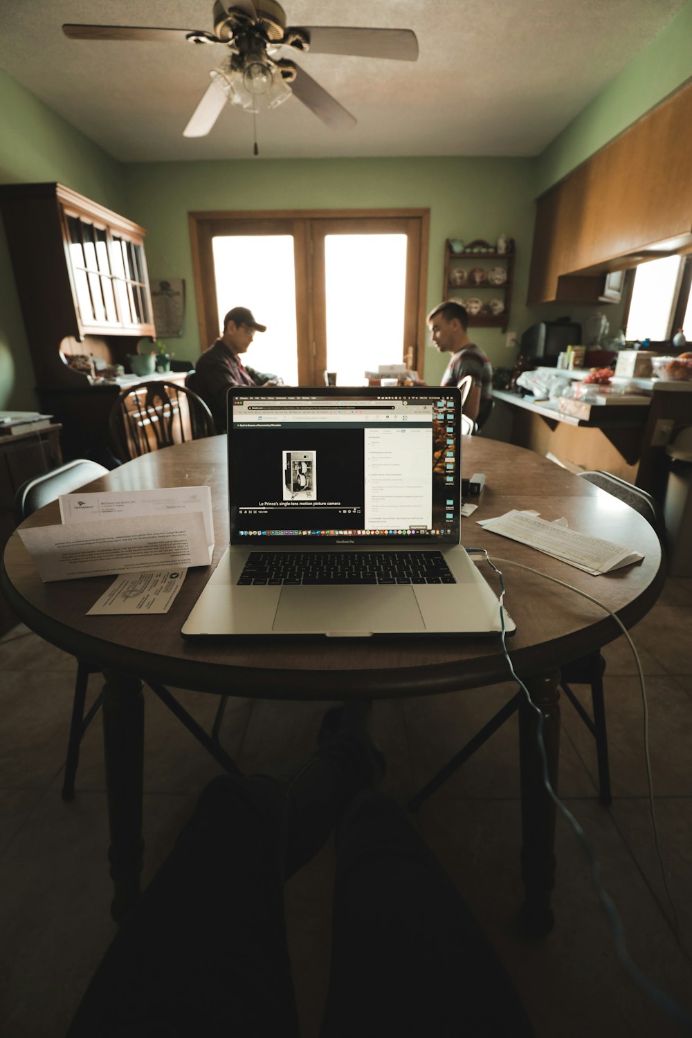 computador portátil preto e prata na mesa de madeira marrom