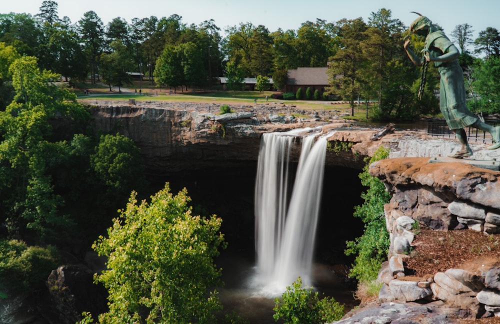 waterfalls near green trees during daytime