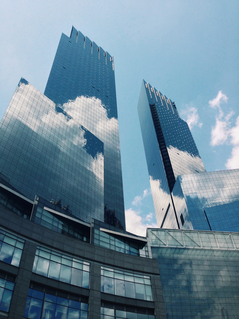 Two skyscrapers dominate the cityscape, one modern glass tower and one traditional building