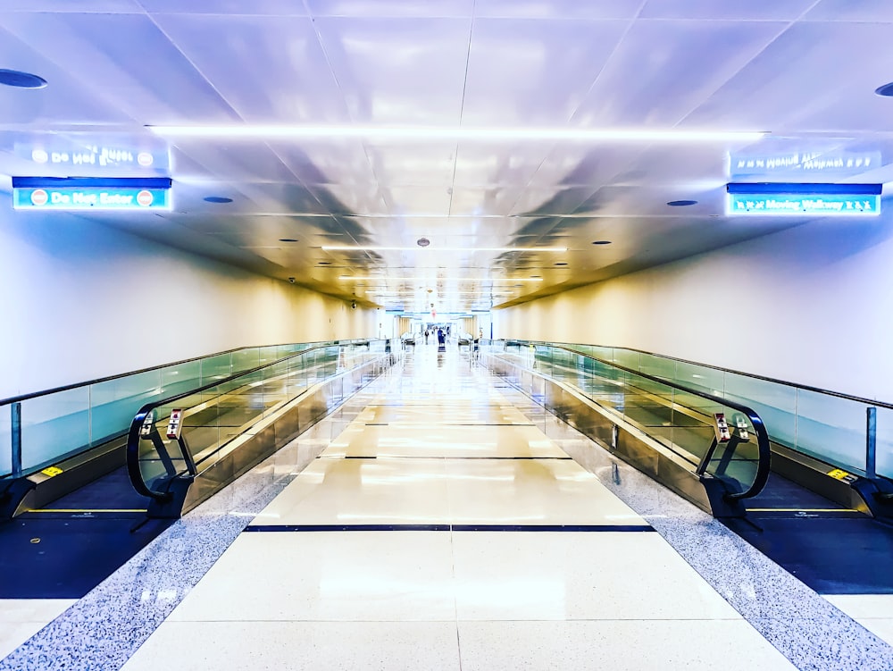 black and silver escalator in a white building