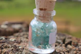Close-up of a crystal jar filled with real Ibiza sand on a sunlit wooden table