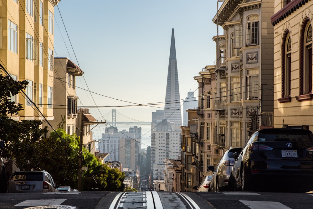 cars parked on side of road near buildings during daytime