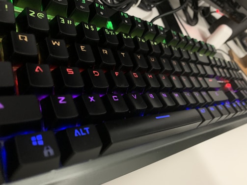 Close-up of a gamer’s hands on a mechanical keyboard with RGB lighting.