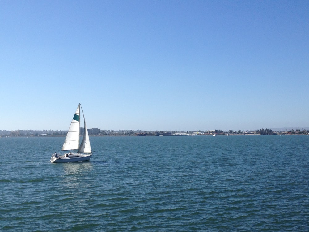 white sailboat on sea under blue sky during daytime