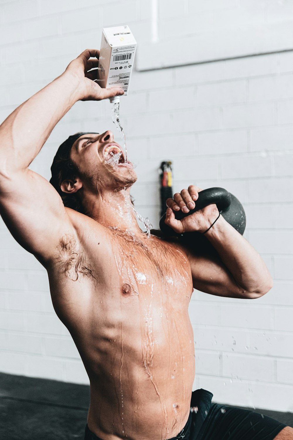 topless man holding black kettle bell