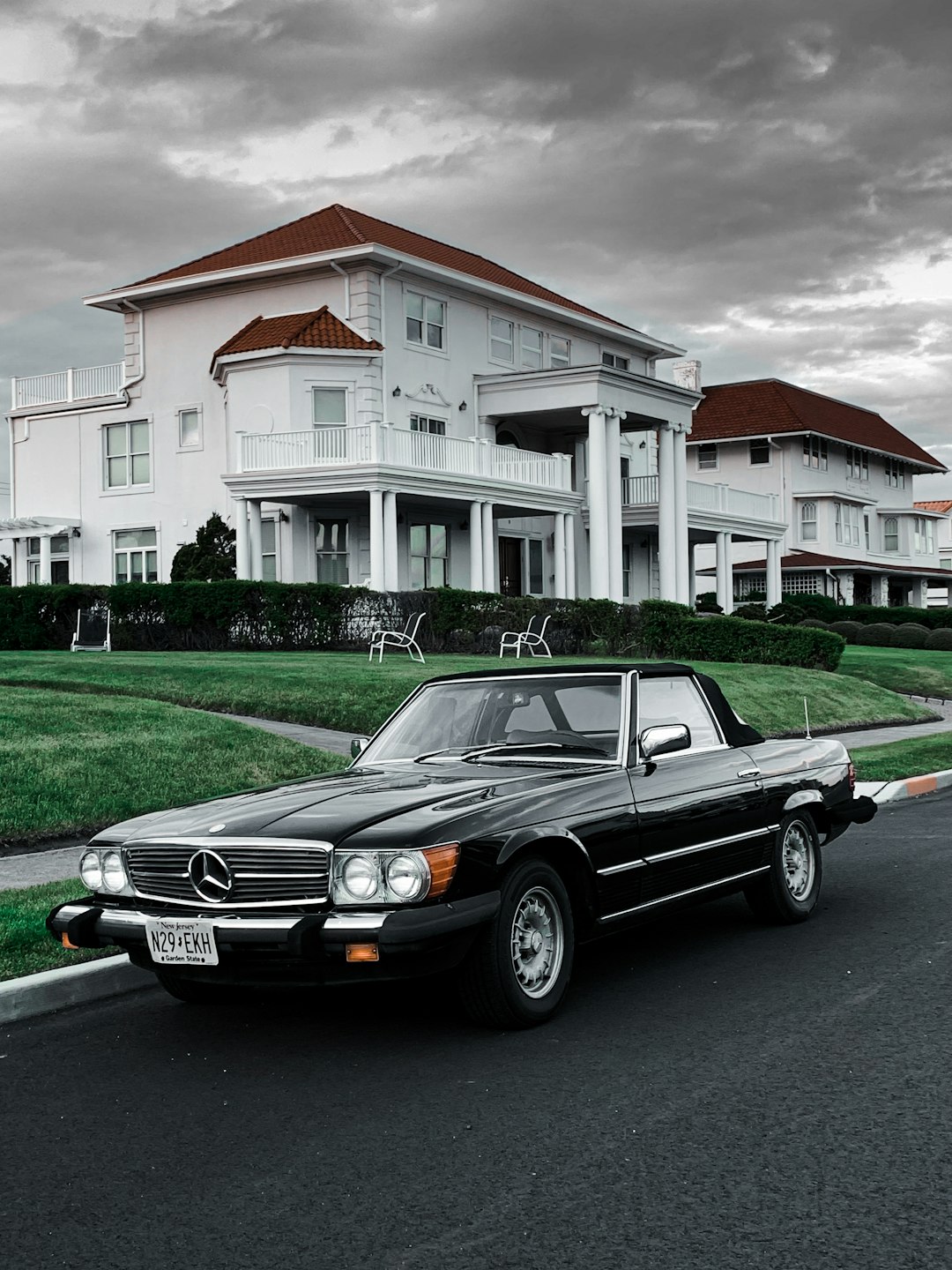 black mercedes benz car parked in front of white and brown house