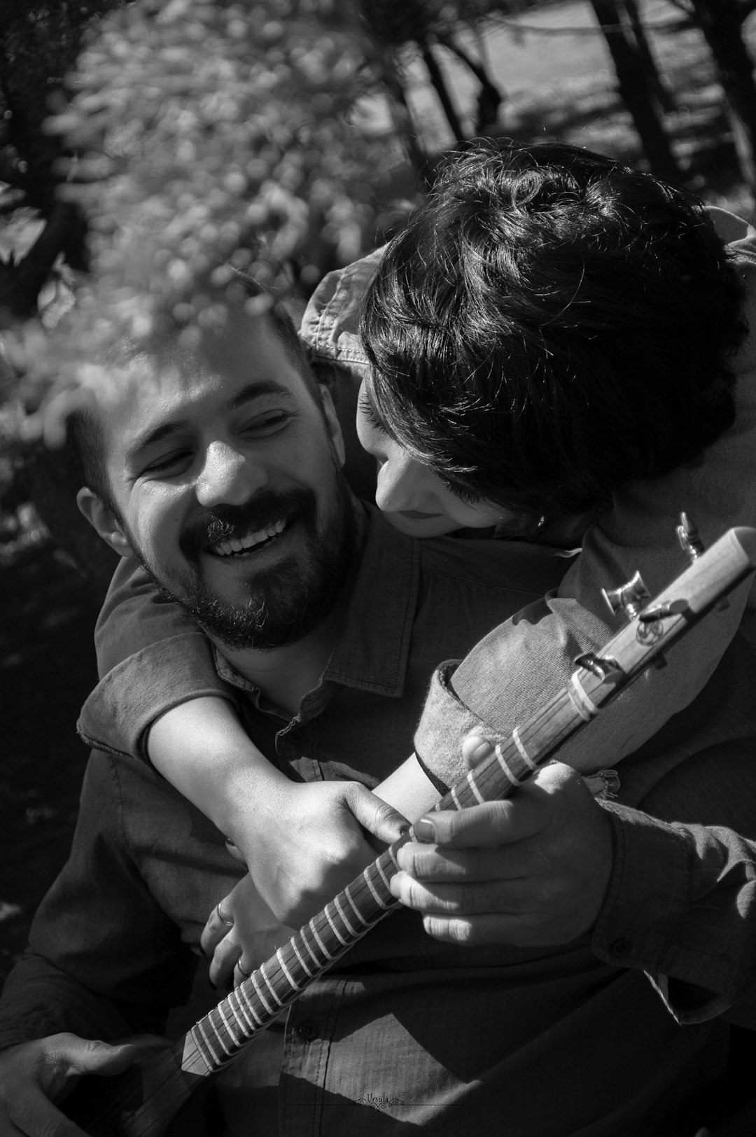 grayscale photo of man playing guitar