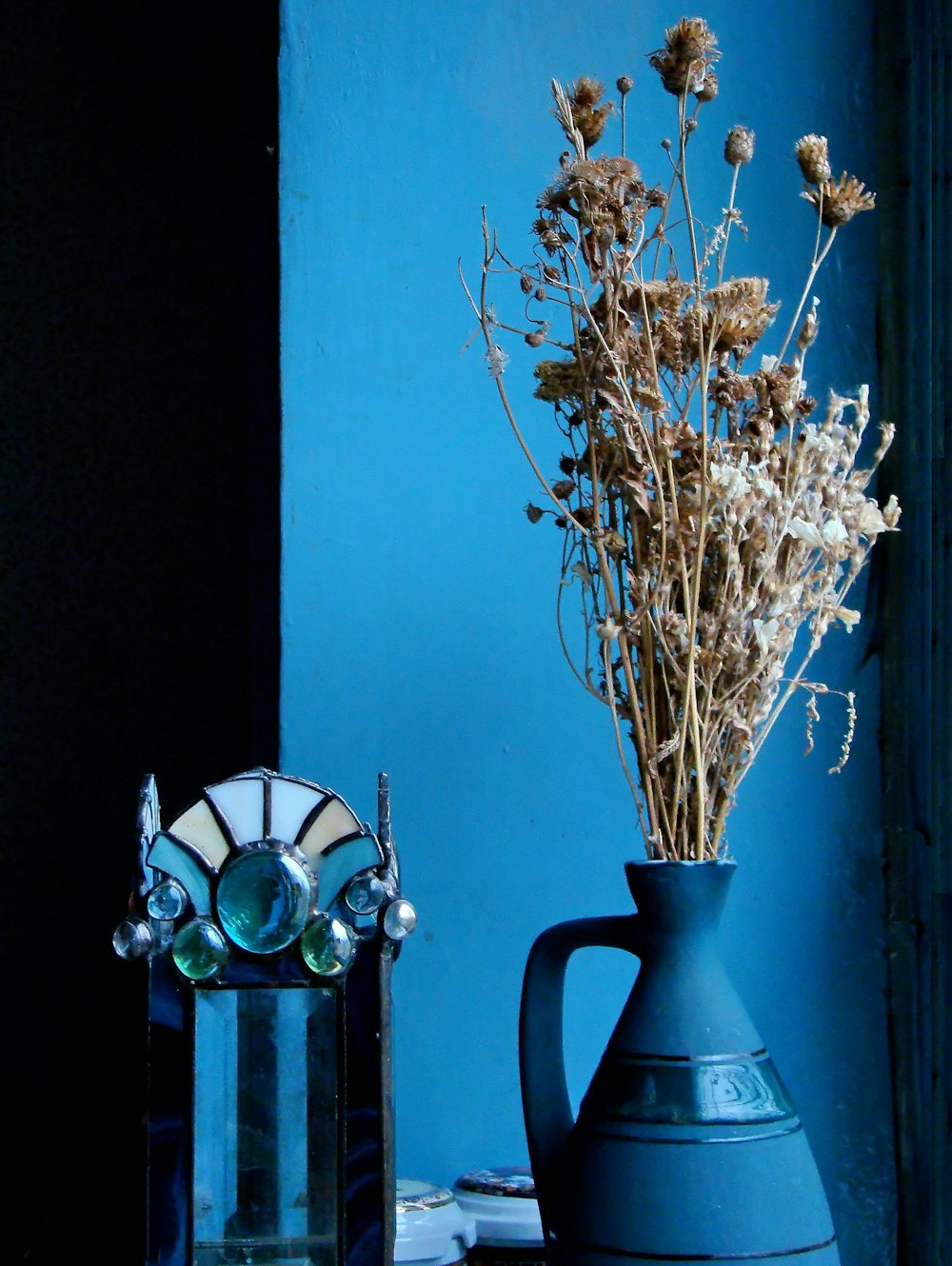 white and green flower in blue ceramic vase
