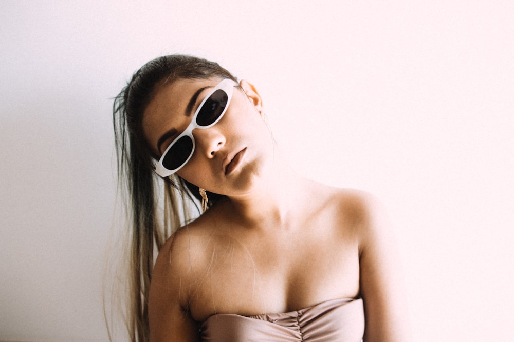 woman in white tube top wearing white framed sunglasses