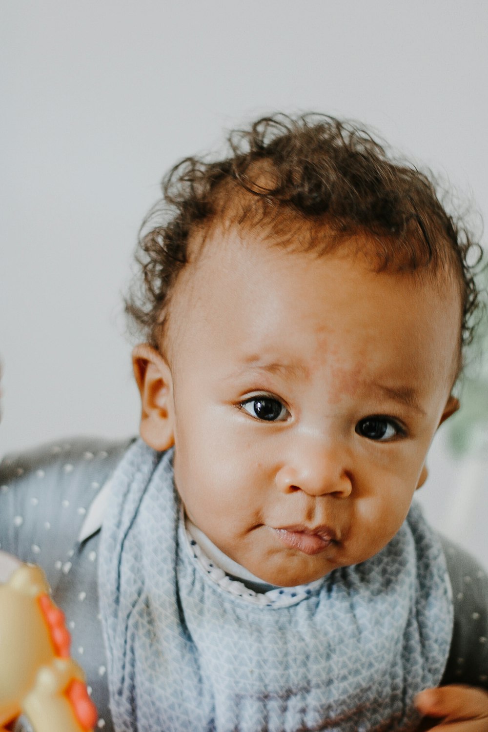 baby in gray and white polka dot shirt