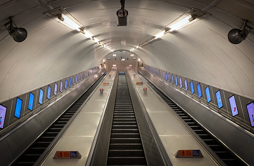 white and black escalator in a tunnel