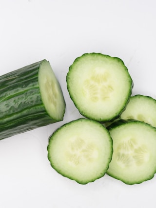 sliced cucumber on white surface