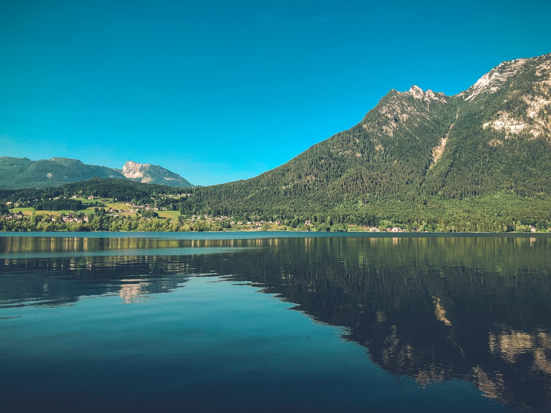 lake near mountain under blue sky during daytime