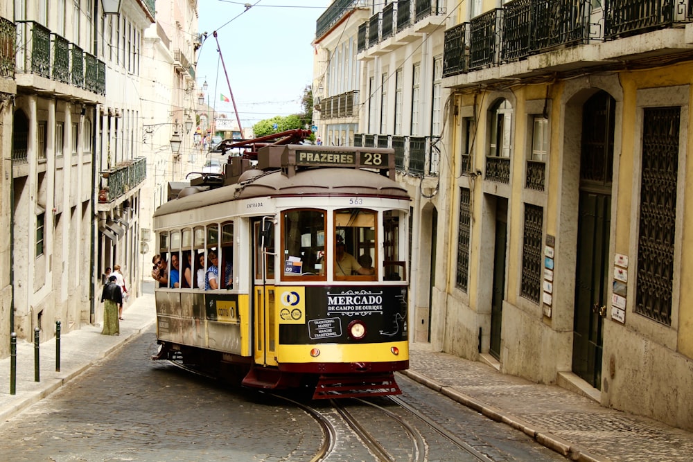 a trolley car is traveling down a narrow street