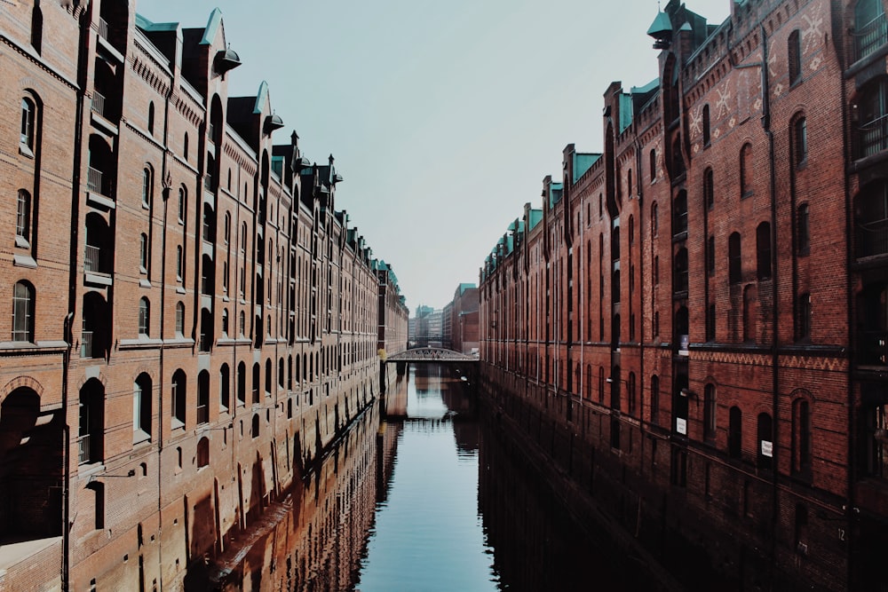 brown concrete building beside river during daytime