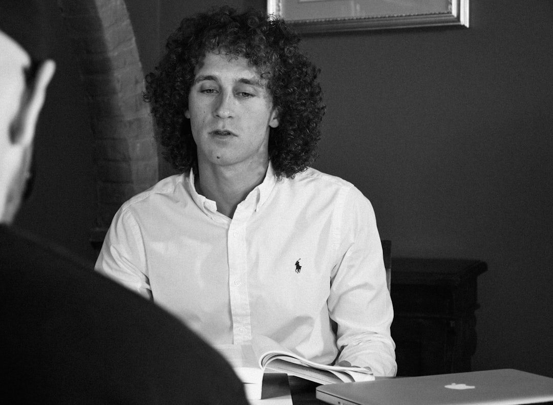 man in white button up shirt sitting on chair