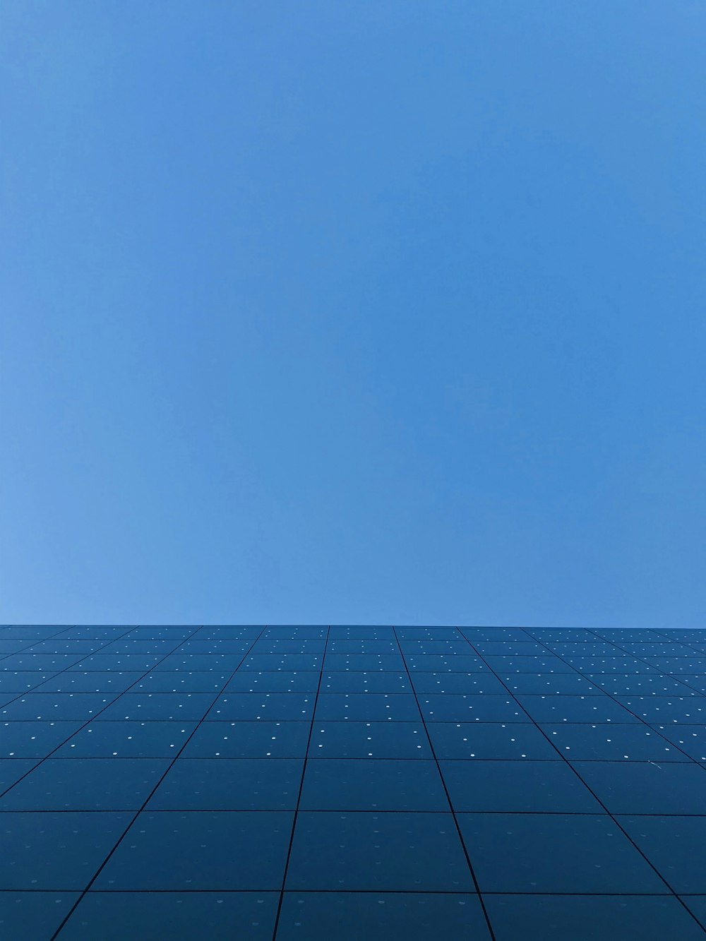 黒と白のコンクリートの建物に青い空