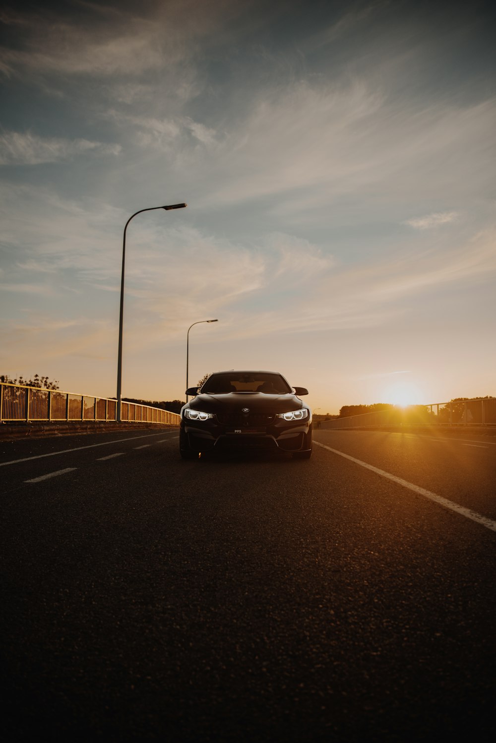 Coche negro en la carretera durante la puesta del sol