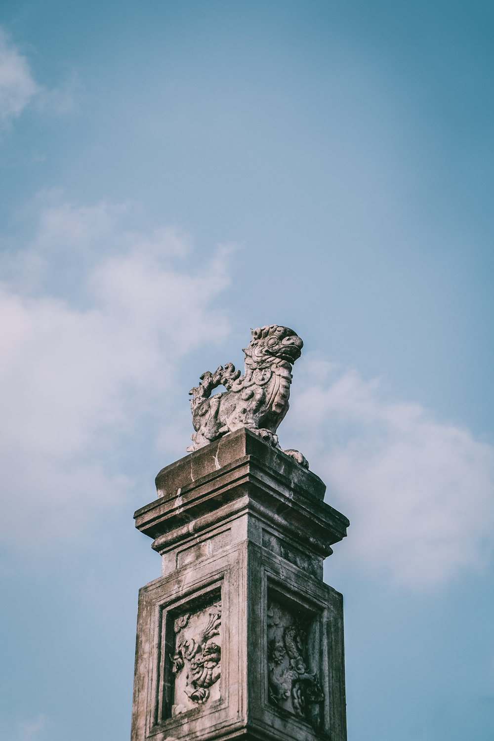 man in hat statue under blue sky during daytime