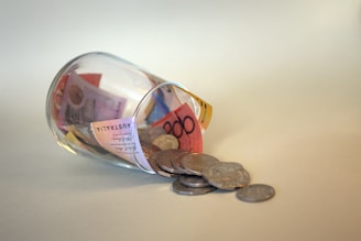 coins and coins in clear glass jar