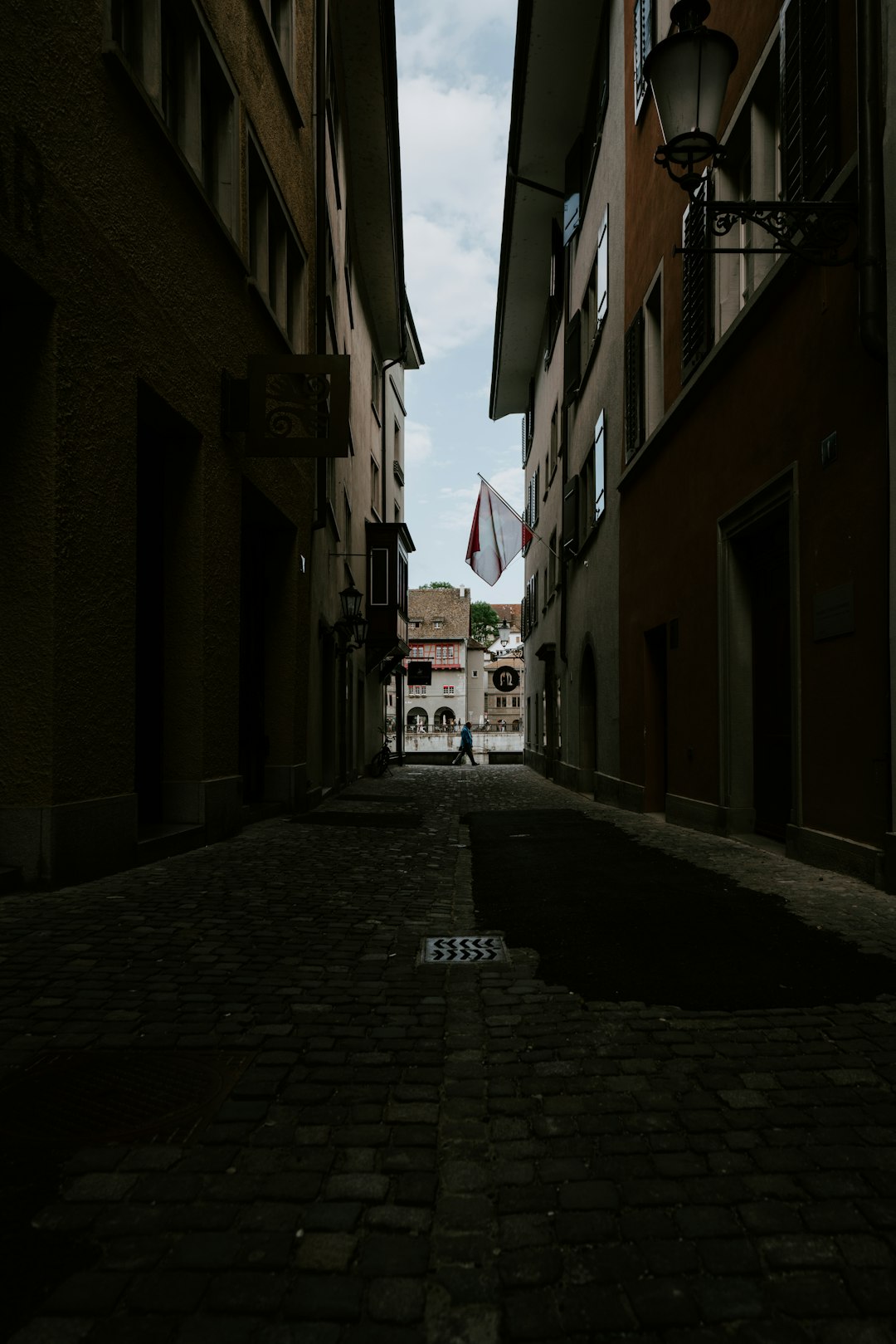 empty street between brown concrete buildings during daytime