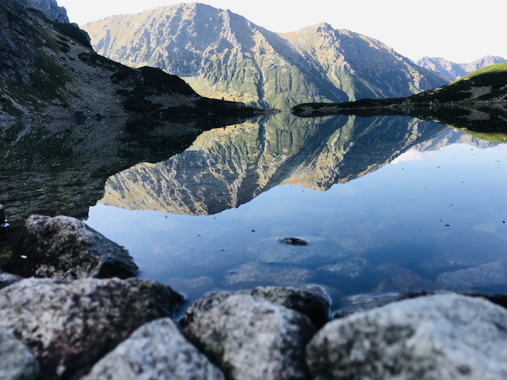 gray rocky mountain near body of water during daytime