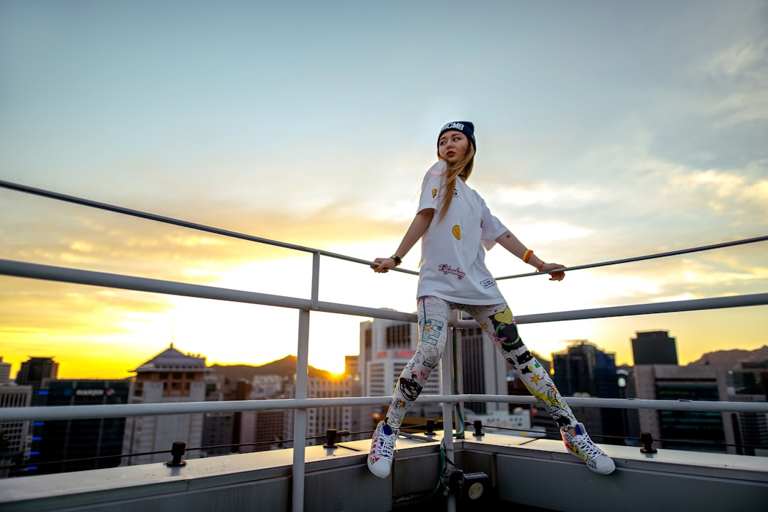 woman in white shirt and pink pants riding skateboard during daytime