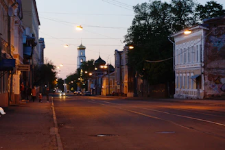 A quiet street scene at dusk with warm lights and subtle shadows.