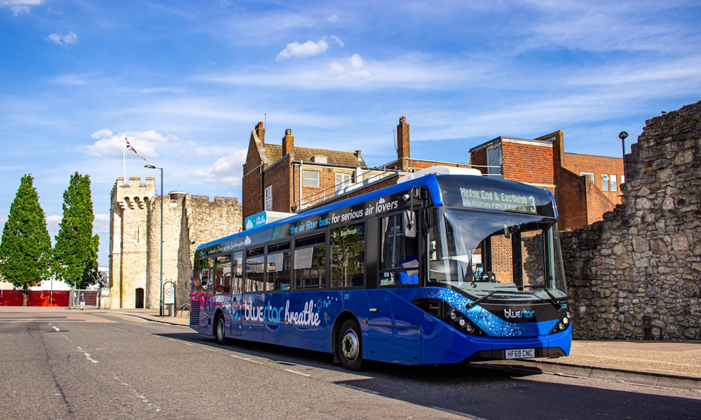 blue and red bus on road near brown building during daytime