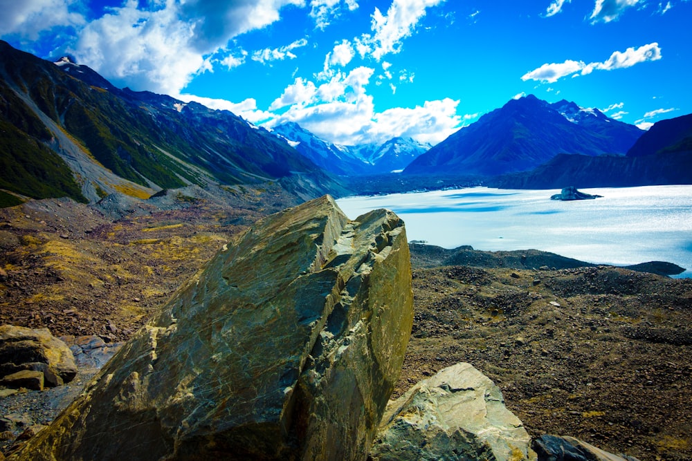 brown and green mountain near body of water during daytime