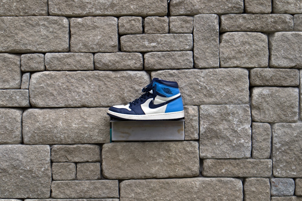 blue and white nike sneakers on gray concrete wall