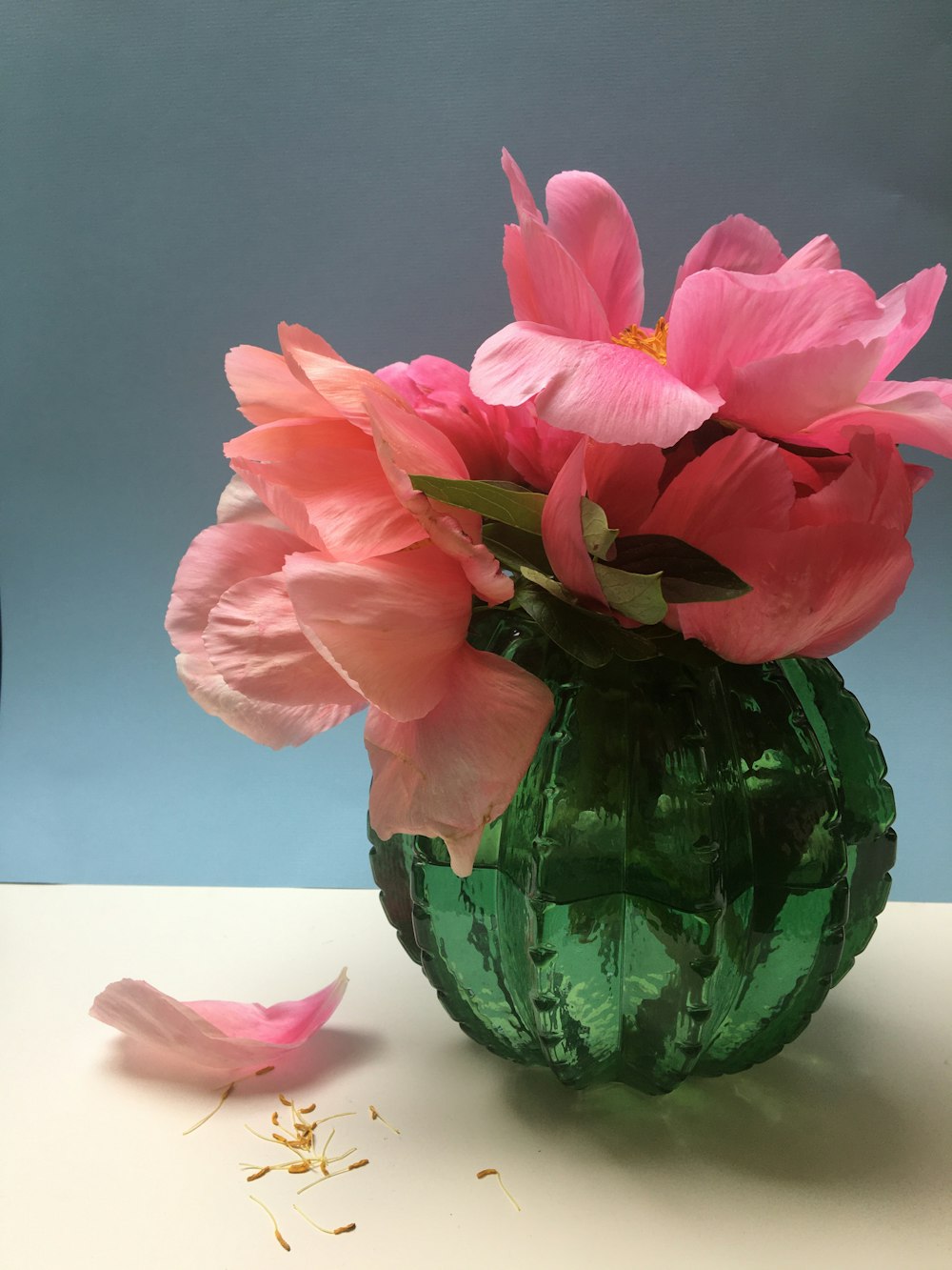 pink flower in green glass vase