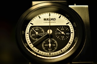 Side profile of a sleek Tissot chronograph with red accents against a clean white background.