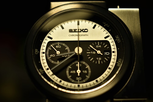 Side profile of a sleek Tissot chronograph with red accents against a clean white background.