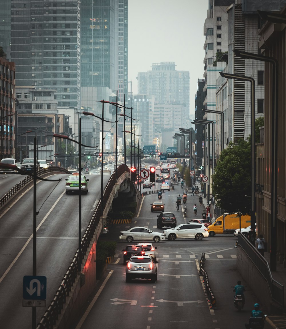 cars on road between high rise buildings during daytime