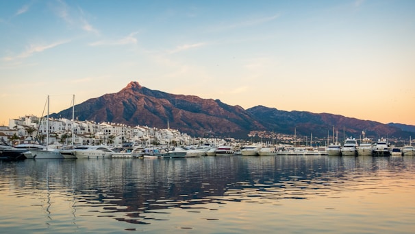 white boats on sea near mountain during daytime