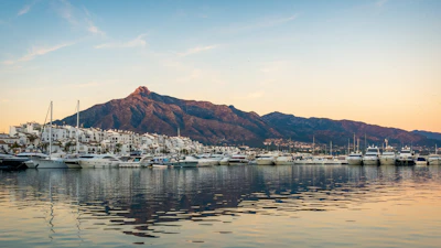 white boats on sea near mountain during daytime
