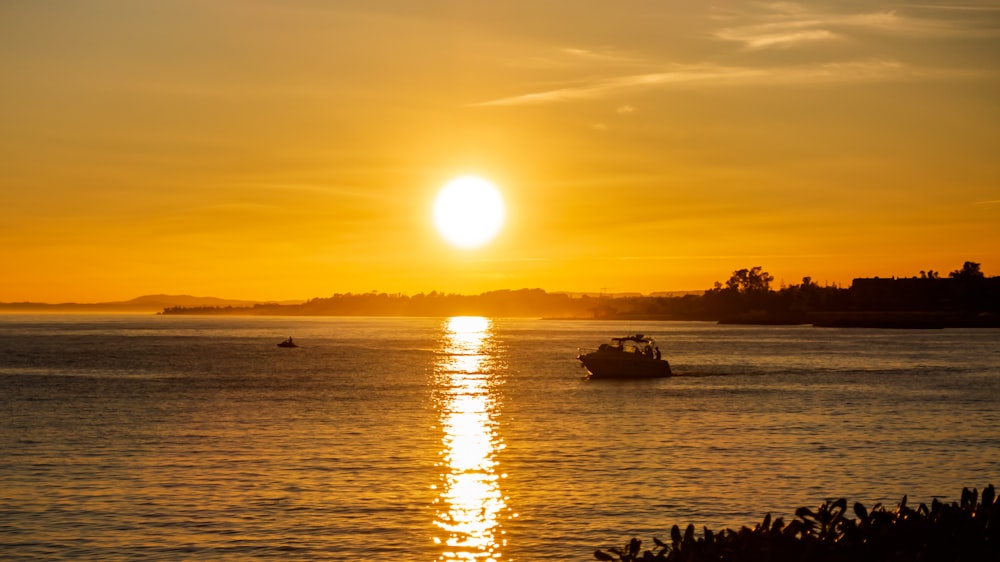 silhouette of boat on sea during sunset