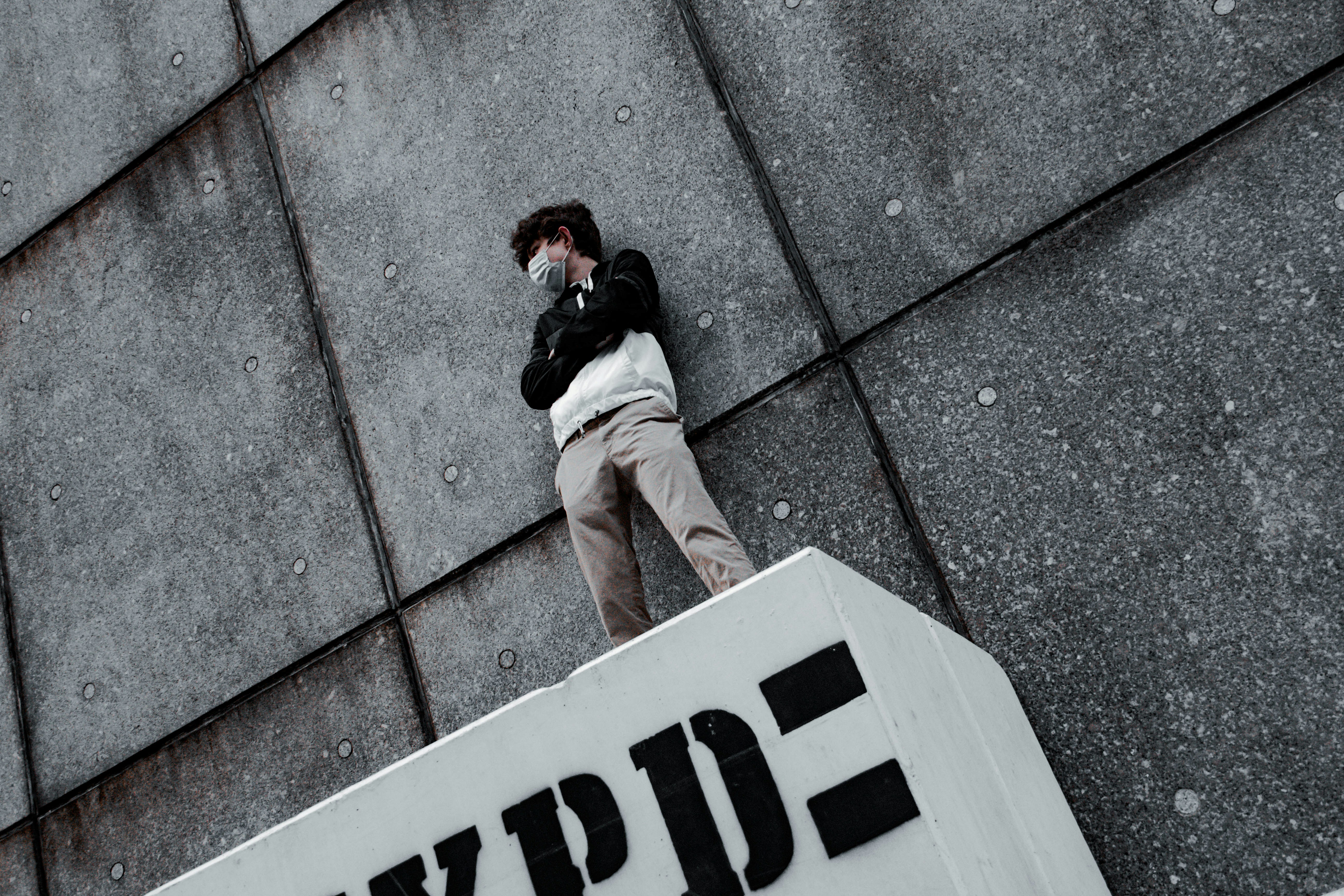 man in white jacket and gray pants standing on gray concrete floor