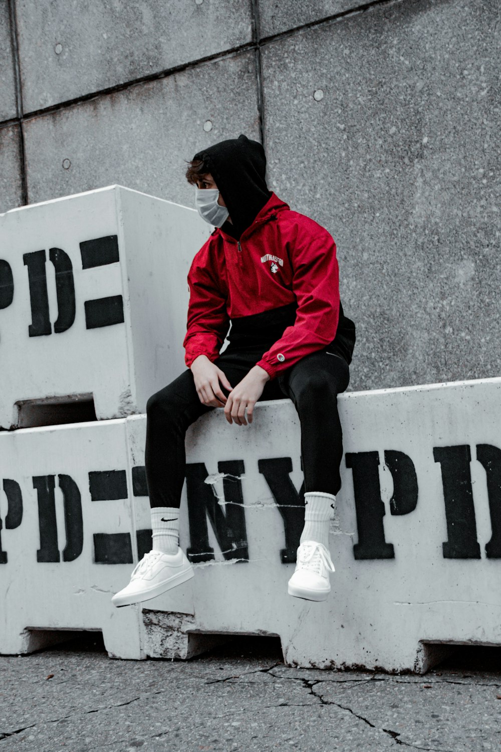 Foto Hombre con chaqueta roja y pantalón negro sentado en blanco y negro  sin señalización de estacionamiento – Imagen Marrón gratis en Unsplash