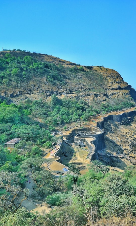 green and brown mountain under blue sky during daytime in Raigad Fort India