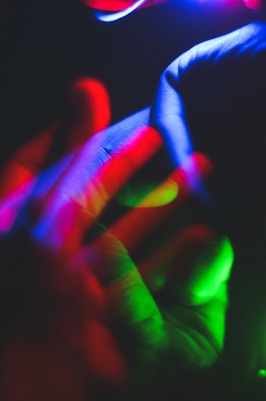 persons hand with purple light