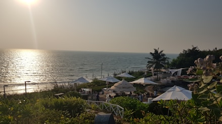 the sun is shining over a beach with umbrellas