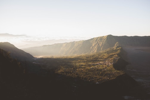 A panoramic view of a serene mountain valley bathed in morning light.