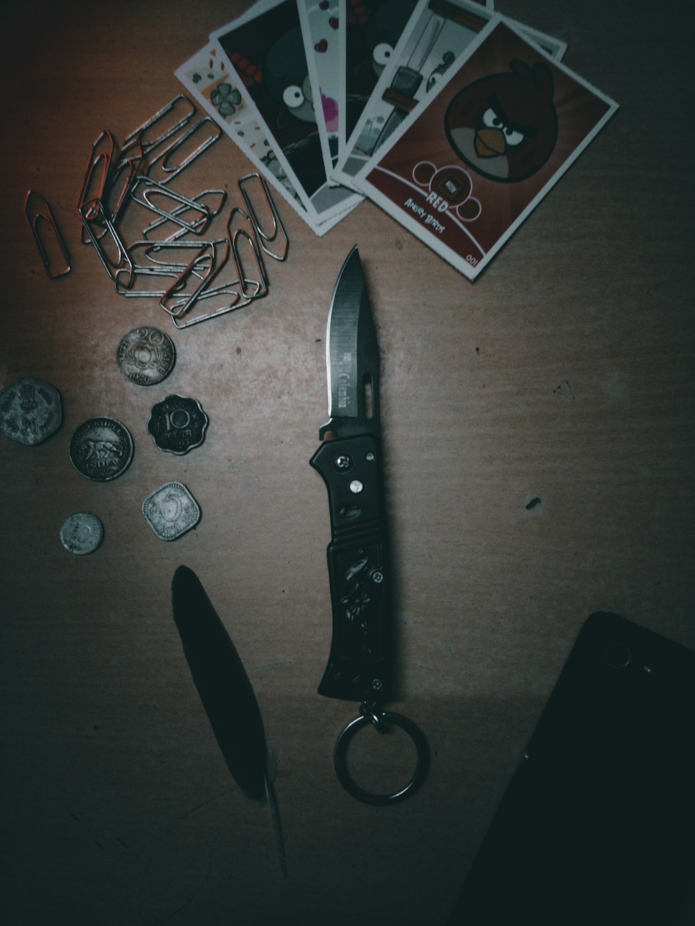 black handle knife beside playing cards