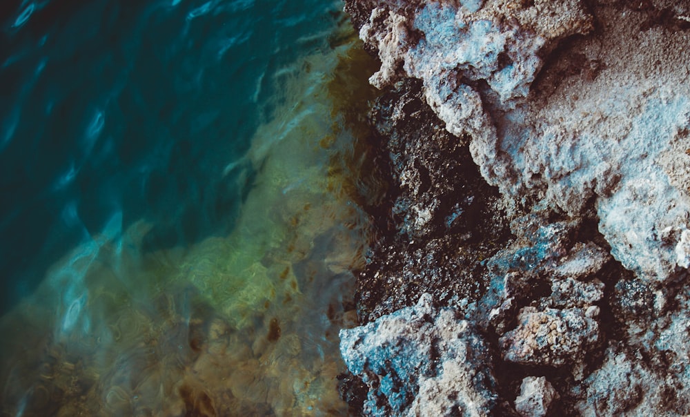 brown and white rock formation on body of water