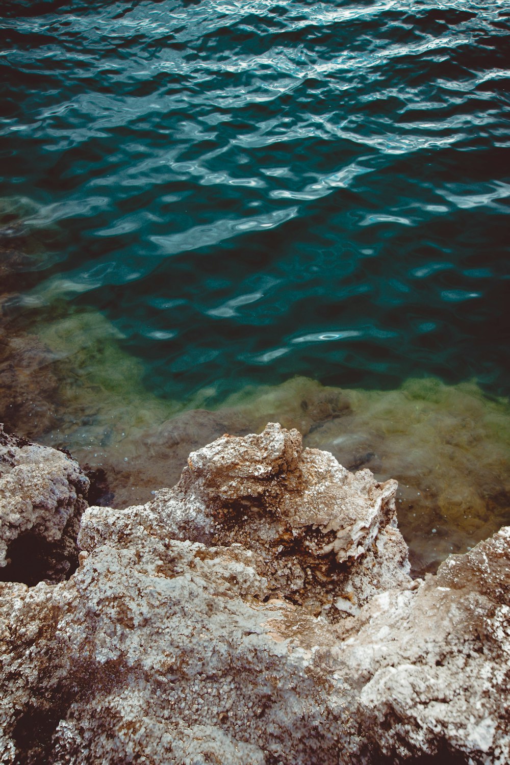 brown and gray rock formation on body of water during daytime