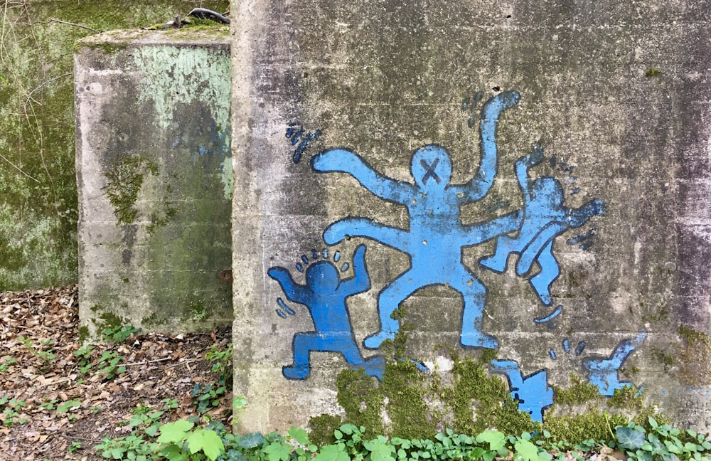 blue and white graffiti on gray concrete wall