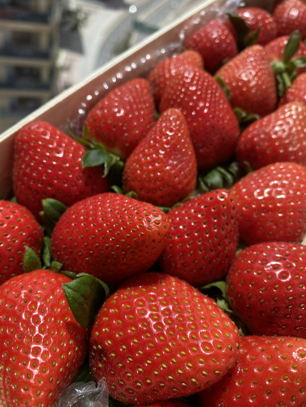red strawberries on white plastic container