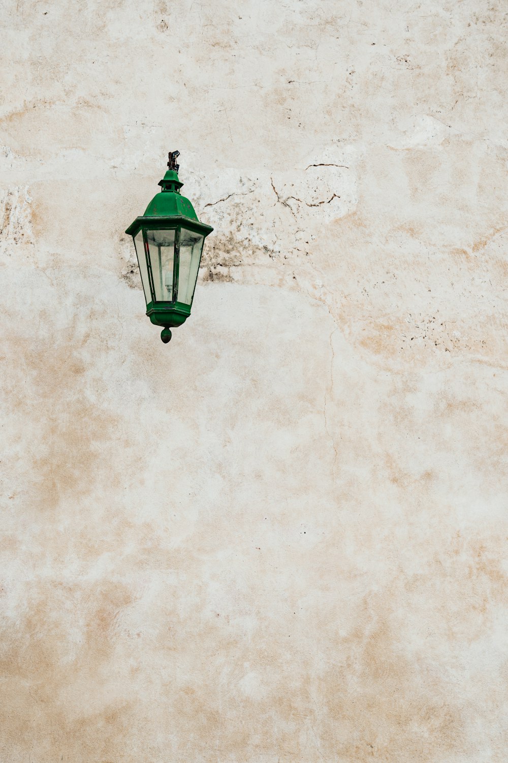 green and black lantern on beige wall